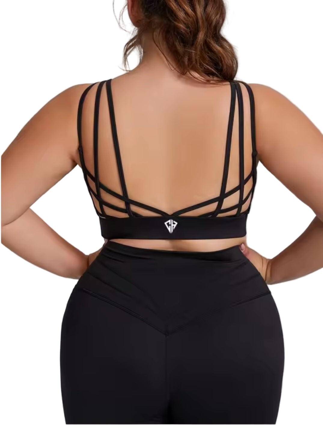 Black sports bra with criss-cross straps worn by a person on a gray background