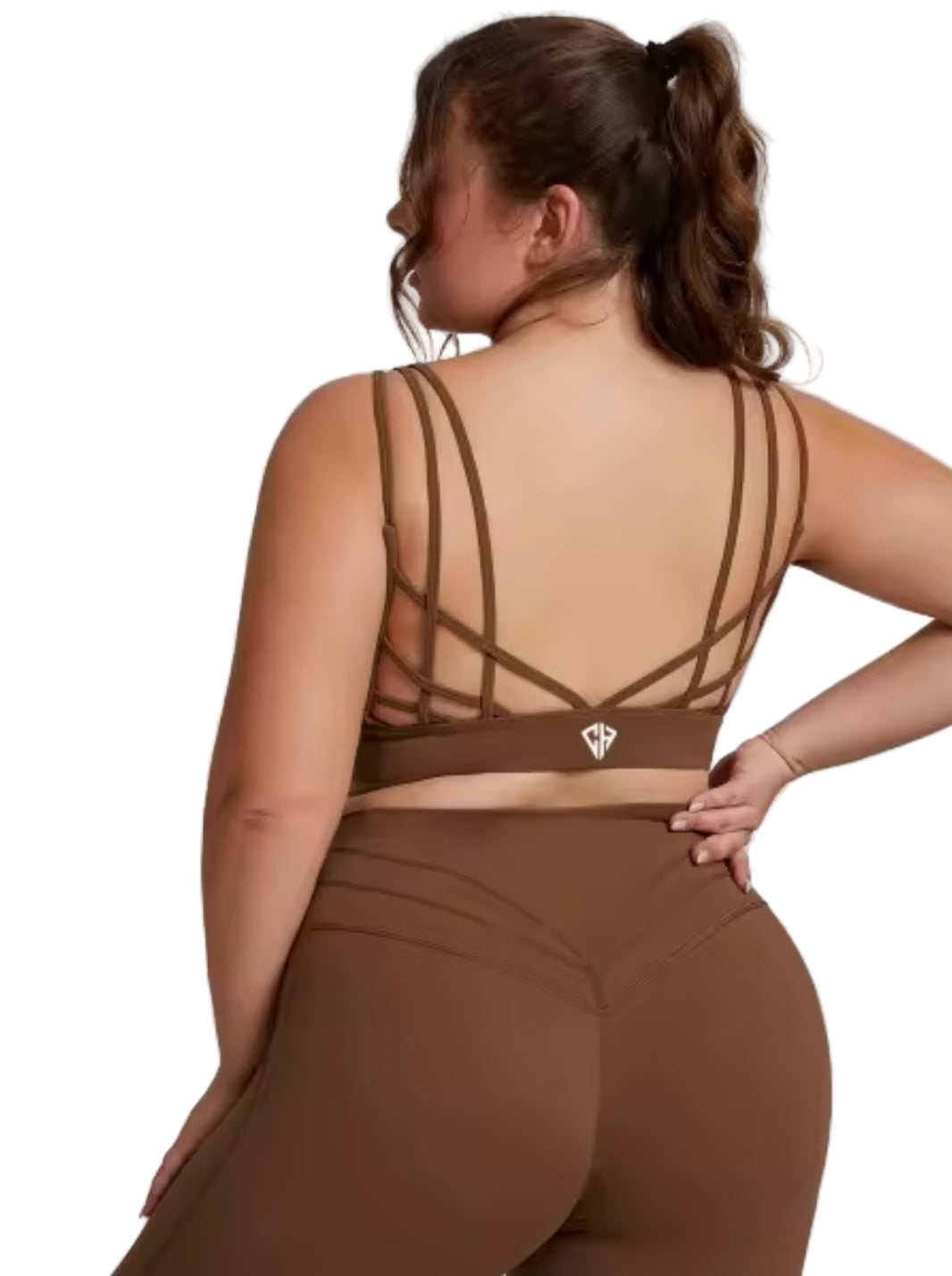 Woman wearing a brown sports bra and leggings on a gray background